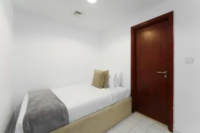 a bedroom with a bed and a wooden door at Maison Privee - Exclusive Duplex Villa with Panoramic Terrace Overlooking Burj Khalifa in Dubai