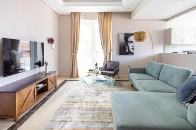 a living room with a blue couch and a glass table at Frank Porter - Mon Reve in Dubai