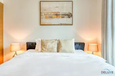 a bedroom with a large white bed with two lamps at Close to Burj Khalifa & Dubai Mall with Relaxing Balcony, Claren Tower 1, Downtown Dubai by Deluxe Holiday Homes in Dubai