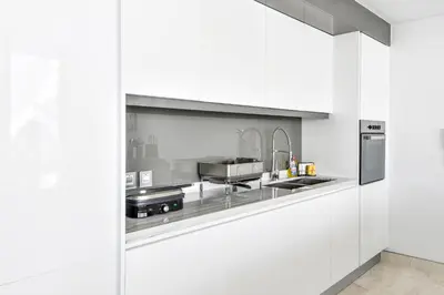 a white kitchen with a sink and a stove at Contemporary and Spacious 2 BR in Bluewaters Island in Dubai