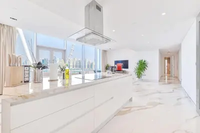 a kitchen with white counters and a large window at Lavish & Equipped oceanfront 2 BR facing Ain Dubai in Dubai