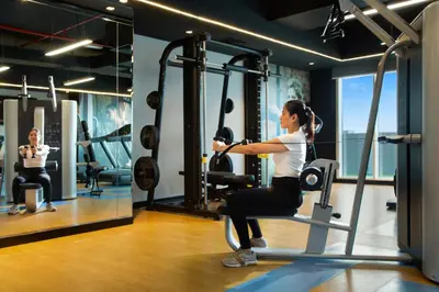 a woman sitting on a exercise bike in a gym at Royal Continental Suites Business Bay - Deluxe Apartments in Dubai