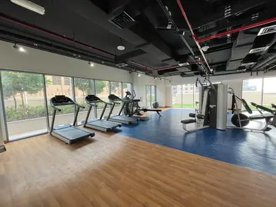a gym with a row of treadmills and machines at BELLEVUE Downtown Dubai in Dubai