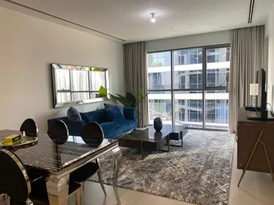 a living room with a blue couch and a table at BELLEVUE Downtown Dubai in Dubai