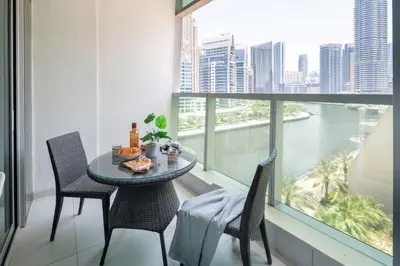 a table and chairs in a balcony with a view at Frank Porter - Panoramic Tower in Dubai
