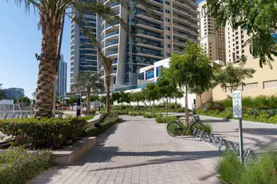 a park with palm trees and a bike on a sidewalk at Frank Porter - Panoramic Tower in Dubai