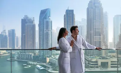 a man and woman standing on top of a skyscraper at Jumeirah Living Marina Gate in Dubai