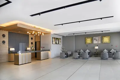 a lobby with chairs and a bar in the middle at Beach Walk Hotel Jumeirah in Dubai