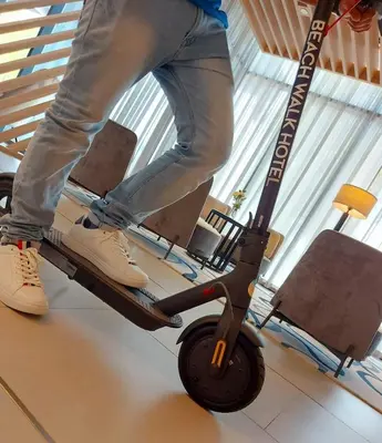 a person standing on a scooter in a room at Beach Walk Hotel Jumeirah in Dubai