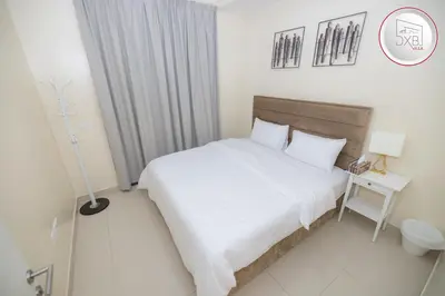 a bedroom with a large white bed and a lamp at 5 bedroom Villa - Dubai Hills in Dubai