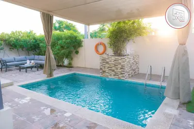 a swimming pool in a yard with a patio at 5 bedroom Villa - Dubai Hills in Dubai