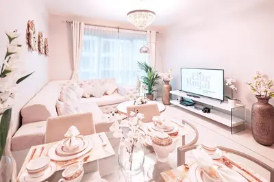 a living room with a white couch and a tv at Elite Royal Apartment - Onyx in Dubai