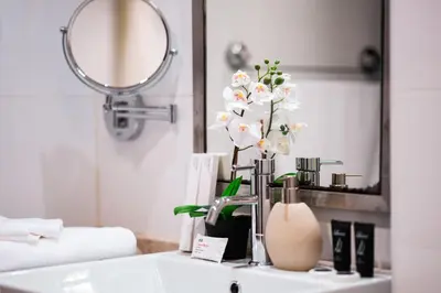 a bathroom with a sink and a vase with flowers at Elite Royal Apartment - Onyx in Dubai