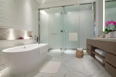 a bathroom with a tub and a glass shower at Al Jaddaf Rotana Dubai in Dubai