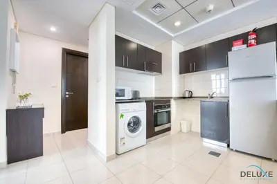 a kitchen with a washer and dryer at Overlooking Marina Canal 1BR Close to Mall, Promenade & Beach, Bay Central 1, Dubai Marina by Deluxe Holiday Homes in Dubai