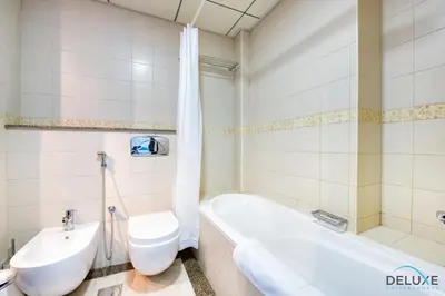 a bathroom with a tub and a toilet and a sink at Overlooking Marina Canal 1BR Close to Mall, Promenade & Beach, Bay Central 1, Dubai Marina by Deluxe Holiday Homes in Dubai