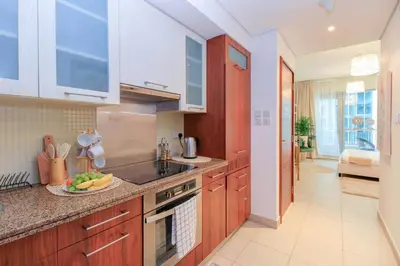 a kitchen with wooden cabinets and a plate of fruit on the counter at Durrani Homes - Luxurious Studio near Dubai Mall with pool view in Dubai