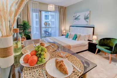 a living room with a bed and a table with food on it at Durrani Homes - Luxurious Studio near Dubai Mall with pool view in Dubai