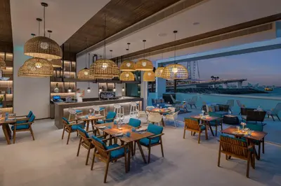 a restaurant with tables and chairs and a bar at Address Beach Resort in Dubai