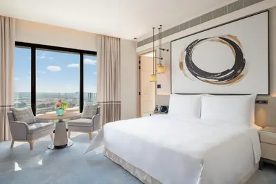 a bedroom with a large white bed and a table and chairs at Address Beach Resort in Dubai