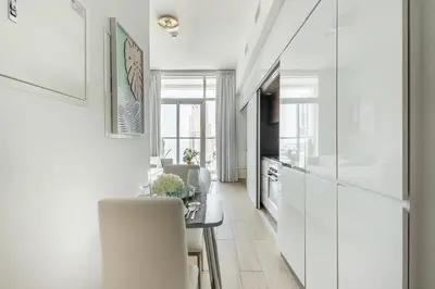 a kitchen with white walls and a table and chairs at Frank Porter - Studio One in Dubai
