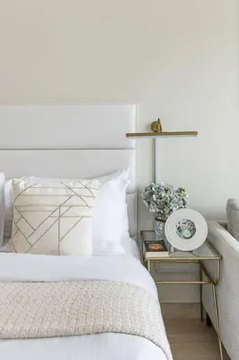 a bedroom with a bed and a side table with a clock at Frank Porter - Studio One in Dubai