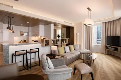 a living room with a couch and a kitchen at Towers Rotana - Dubai in Dubai