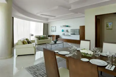a living room with a dining table and a living room at Jumeira Rotana – Dubai in Dubai