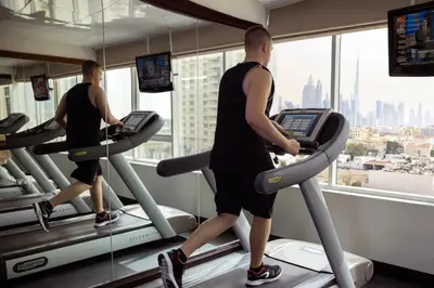 two men running on treadmill in a gym at Jumeira Rotana – Dubai in Dubai