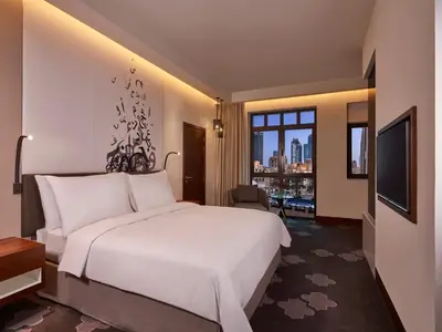 a hotel room with a large bed and a television at The Heritage Hotel, Autograph Collection, Downtown Dubai in Dubai