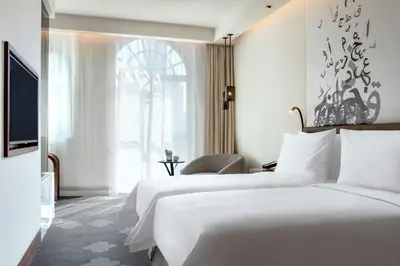 a hotel room with two beds and a window at The Heritage Hotel, Autograph Collection, Downtown Dubai in Dubai