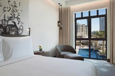 a bedroom with a bed and a chair and a window at The Heritage Hotel, Autograph Collection, Downtown Dubai in Dubai