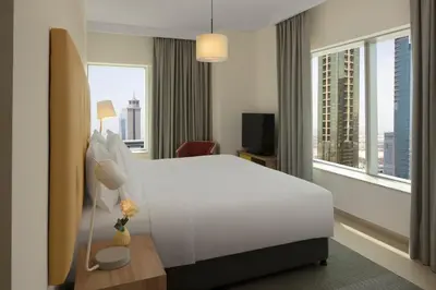 a hotel room with a white bed and a large window at Staybridge Suites Dubai Financial Centre by IHG in Dubai