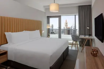 a bedroom with a large bed and a large window at Staybridge Suites Dubai Financial Centre by IHG in Dubai