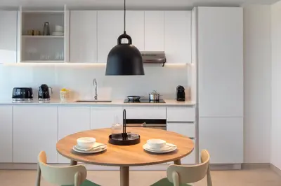 a kitchen with a wooden table and chairs at Staybridge Suites Dubai Financial Centre by IHG in Dubai