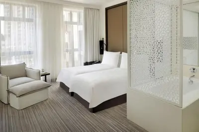a hotel room with a bed and a chair at Hotel Boulevard, Autograph Collection, Downtown Dubai in Dubai