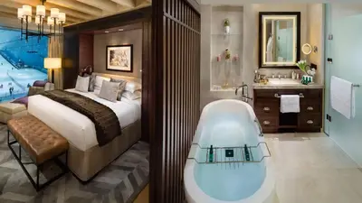 a bathroom with a tub next to a bed and a bath room at Kempinski Hotel Mall of the Emirates, Dubai in Dubai