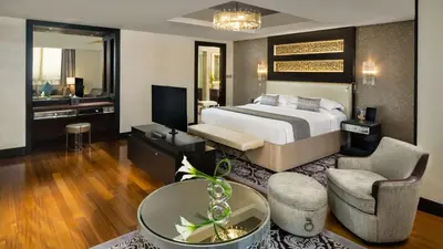 a hotel room with a bed and a living room at Kempinski Hotel Mall of the Emirates, Dubai in Dubai