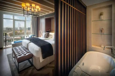 a bedroom with a bed and a bath tub at Kempinski Hotel Mall of the Emirates, Dubai in Dubai