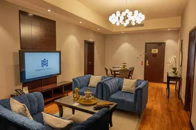 a living room with blue couches and a flat screen tv at Majestic City Retreat Hotel in Dubai