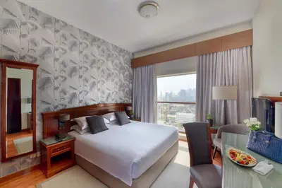 a hotel room with a bed and a desk at Majestic City Retreat Hotel in Dubai