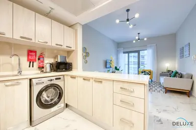 a kitchen with a washer and dryer in a room at Distance Away From Expo City Dubai 1BR Unit, MAG 510, Madinat Al Mataar by Deluxe Holiday Homes in Dubai