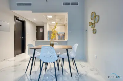 a dining room with a table and chairs at Distance Away From Expo City Dubai 1BR Unit, MAG 510, Madinat Al Mataar by Deluxe Holiday Homes in Dubai