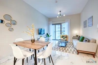 a living room with a table and chairs and a couch at Distance Away From Expo City Dubai 1BR Unit, MAG 510, Madinat Al Mataar by Deluxe Holiday Homes in Dubai