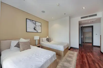 a hotel room with two beds and a hallway at Luxe Getaways Royal Amwaj Palm Jumeirah Resort Apartment Holiday Home in Dubai