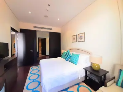 a bedroom with a white bed and a television at Luxe Getaways Royal Amwaj Palm Jumeirah Resort Apartment Holiday Home in Dubai