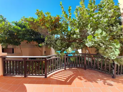 a wooden fence with a tree in front of a building at Luxe Getaways Royal Amwaj Palm Jumeirah Resort Apartment Holiday Home in Dubai