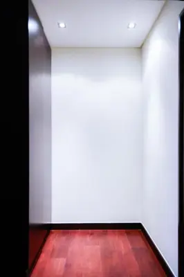 a room with a white wall and a wooden floor at Luxe Getaways Royal Amwaj Palm Jumeirah Resort Apartment Holiday Home in Dubai
