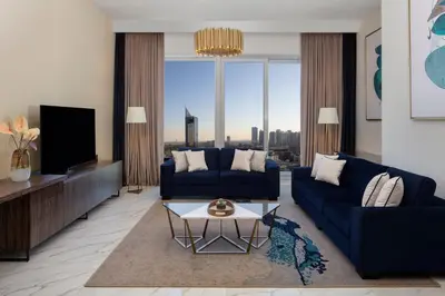 a living room with a blue couch and a tv at Avani Plus Palm View Dubai Hotel & Suites in Dubai