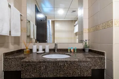 a bathroom with a sink and a large mirror at The Smart Concierge - Bay Central in Dubai